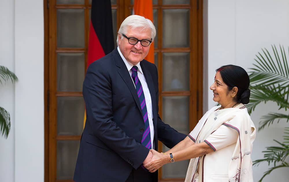 German Foreign Minister Frank-Walter Steinmeier, left, poses for photographers while shaking hands with his Indian counterpart Sushma Swaraj in New Delhi.