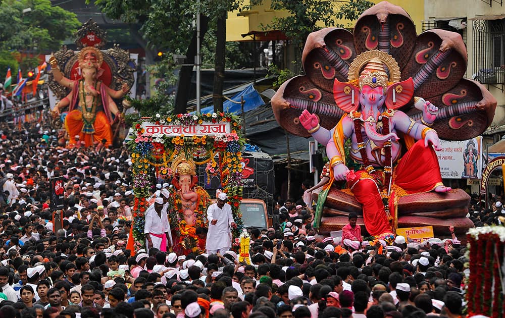 Hindu devotees walk in a procession with large statues of the Hindu god Ganesh to immerse them in the Arabian Sea on the final day of the festival of Ganesh Chaturthi in Mumbai.