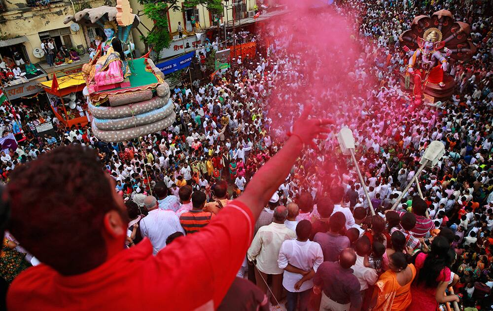 Devotees throw colored powder as they prepare to immerse an idol of Hindu god Ganesha in the Arabian Sea during Ganesh Chaturthi festival celebrations, in Mumbai.