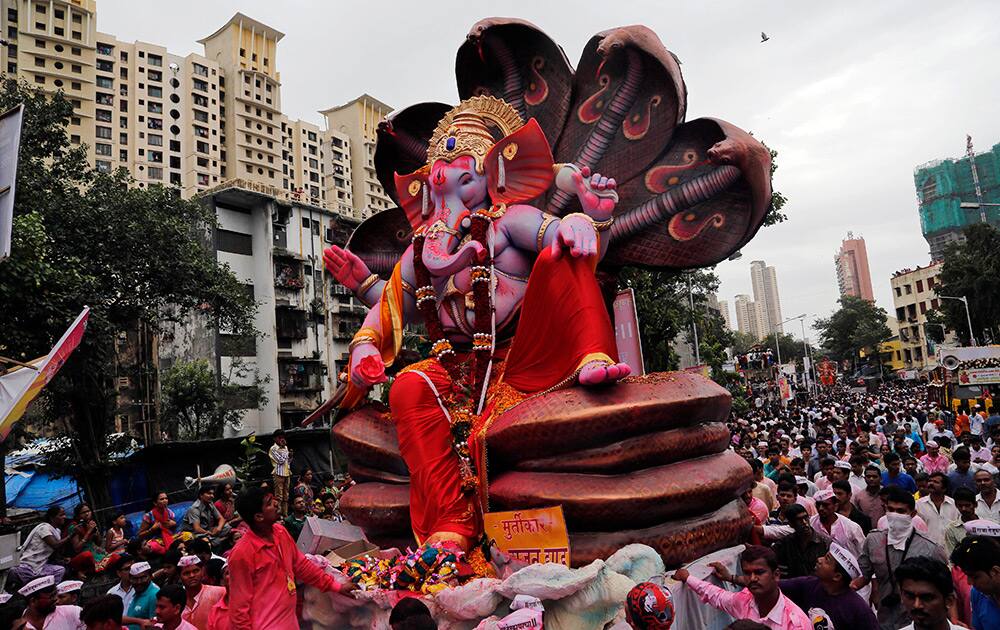 Hindu devotees walk as a large statue of the Hindu god Ganesh is taken in a procession for immersion in the Arabian Sea on the final day of the festival of Ganesh Chaturthi in Mumbai.