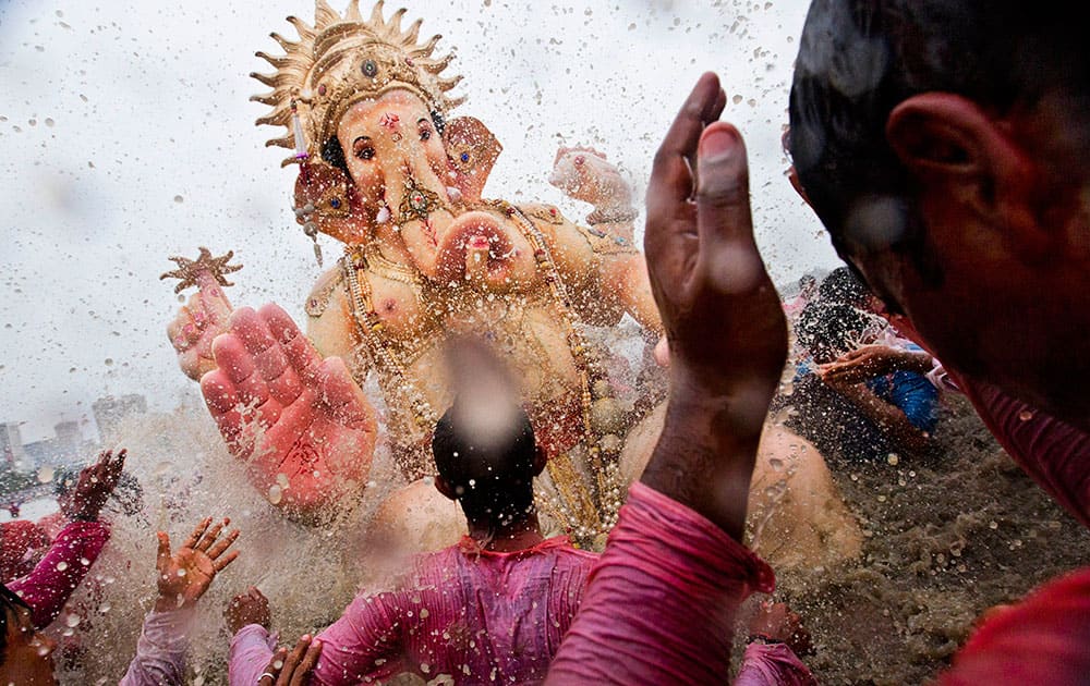 Indian Hindu devotees splash water on a large statue of the elephant-headed Hindu God Ganesha before immersing it in the Arabian Sea on the final day of the festival of Ganesha Chaturthi in Mumbai.