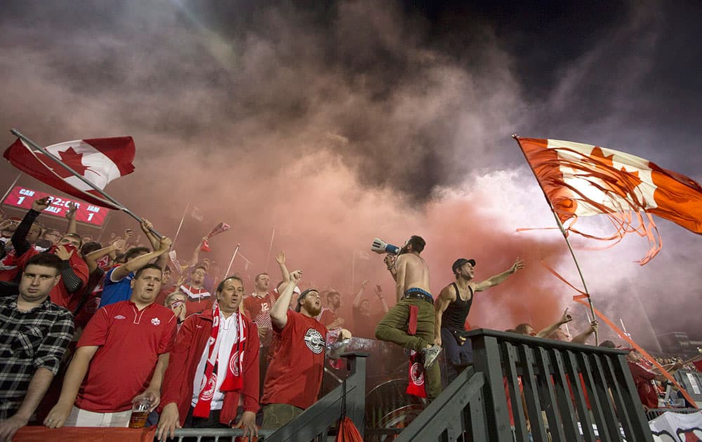 Canadian fans cheer amidst smoke from a smoke bomb following Canada's tying goal against Jamaica during first half of an international friendly soccer game in Toronto.