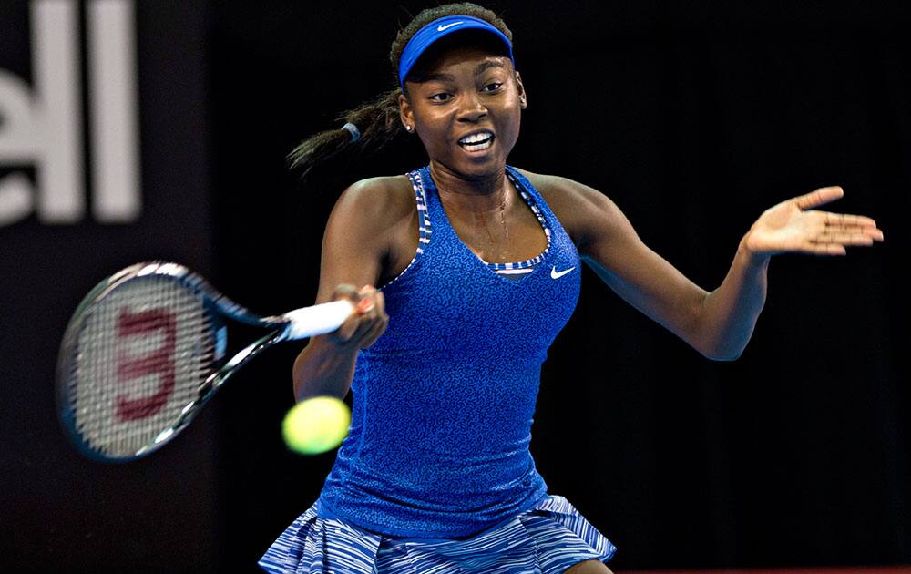 Francoise Abanda, of Canada, returns to Venus Williams, of the United States, during the first round of the Banque Nationale tennis tournament.