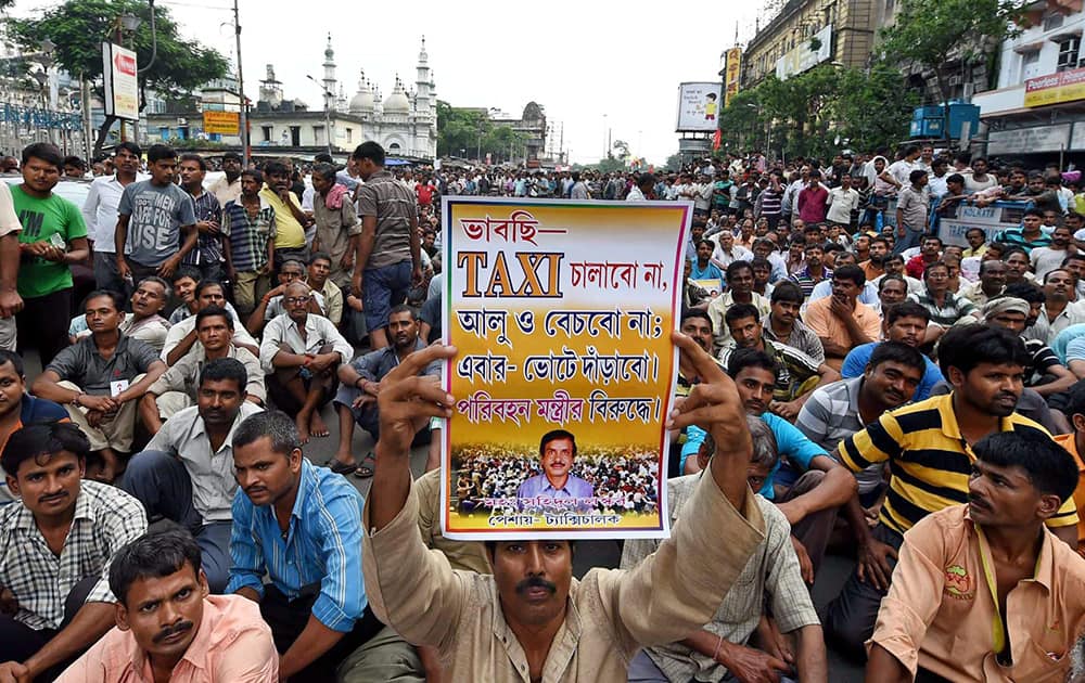 A taxi driver displays a placard during a protest rally against the West Bengal government in Kolkata.