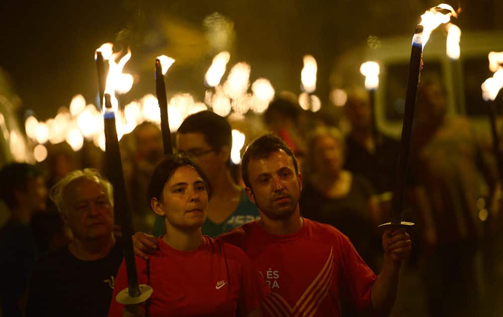 People hold torches during a march for the independence of Catalonia in Barcelona, Spain.