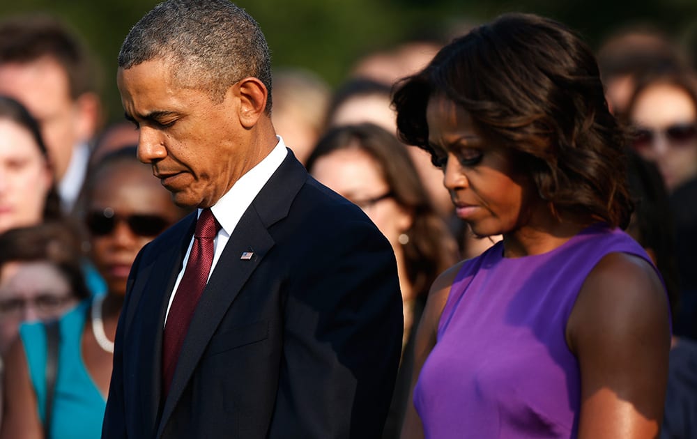 FILE - In this Sept. 11, 2013, file photo, President Barack Obama and first lady Michelle Obama stand for a moment of silence on the South Lawn at the White House in Washington, as they mark the 12th anniversary of the September 11 terror attacks. Five times, Obama has come before the American people to reckon with the legacy of the 9/11 terrorist attacks on the anniversary of that awful day. 