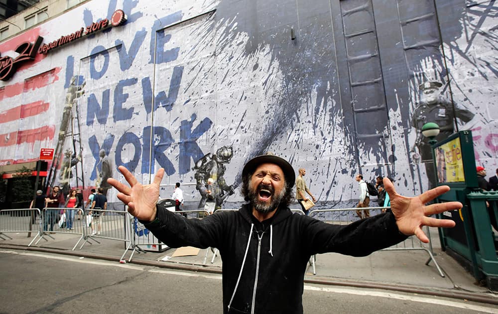 Street artist Thierry Guetta poses for a portrait in front of the mural '9/11' that he installed on the facade of the Century 21 department store, in New York. The installation, which will last three weeks, is an homage to New Yorkers who endured the terror attacks of Sept. 11, 2001.