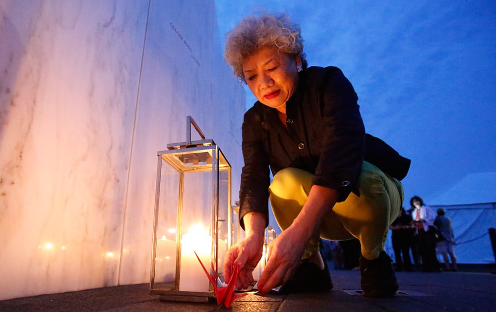 Yachiyo Kuge, the mother of Toshiya Kuge who was a passenger on Flight 93, places origami birds near his name, at the Wall of Names at the Flight 93 National Memorial in Shanksville, Pa.. Thursday marks the 13th anniversary of the Sept. 11 terror attacks.