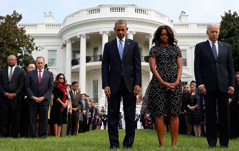 President Barack Obama, first lady Michelle Obama, Vice President Joe Biden, and others, bow their heads as they stand on the South Lawn of the White House in Washington, as they observe a moment of silence to mark the 13th anniversary of the 9/11 attacks.