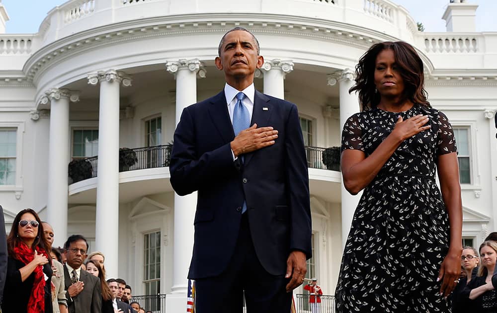 President Barack Obama and first lady Michelle Obama stand on the South Lawn of the White House in Washington, during the playing of Taps to mark the 13th anniversary of the 9/11 attacks.