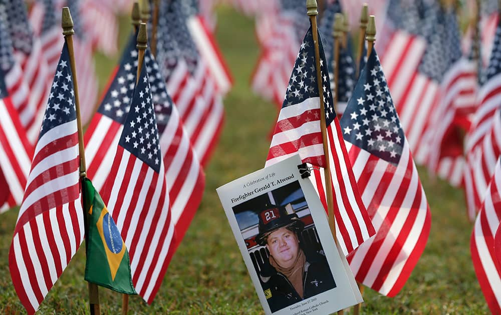 A memorial for firefighter Gerald T. Atwood is attached to an American flag in a sea of American flags during a memorial in Matthews, N.C., on the 13th anniversary of the Sept. 11, 2001 attacks.