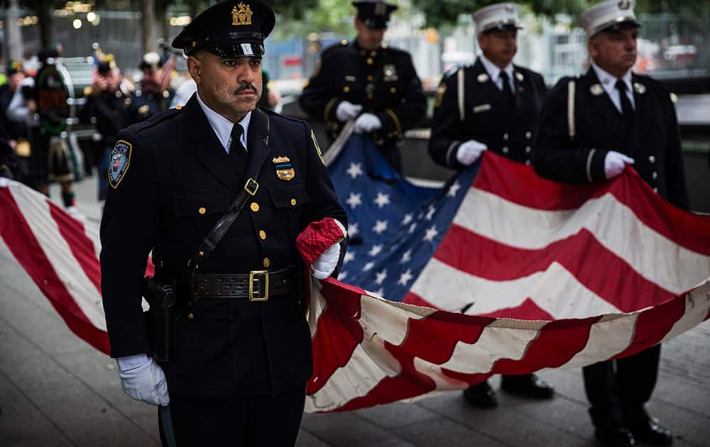 Members of the New York Police Department, Fire Department of New York and Port Authority of New York and New Jersey Police Department carry an American flag at the beginning of the memorial observances on the 13th anniversary of the Sept. 11 terror attacks on the World Trade Center in New York.