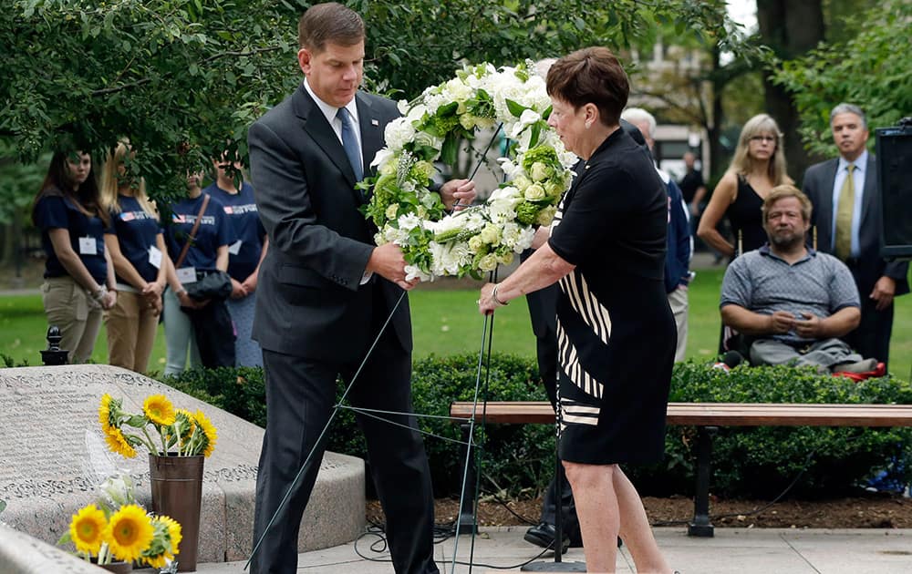 Boston Mayor Martin Walsh, left, and Maureen Gilligan place a wreath during a ceremony commemorating the anniversary of the terrorist attacks, at the 9/11 Memorial at the Public Garden in Boston.