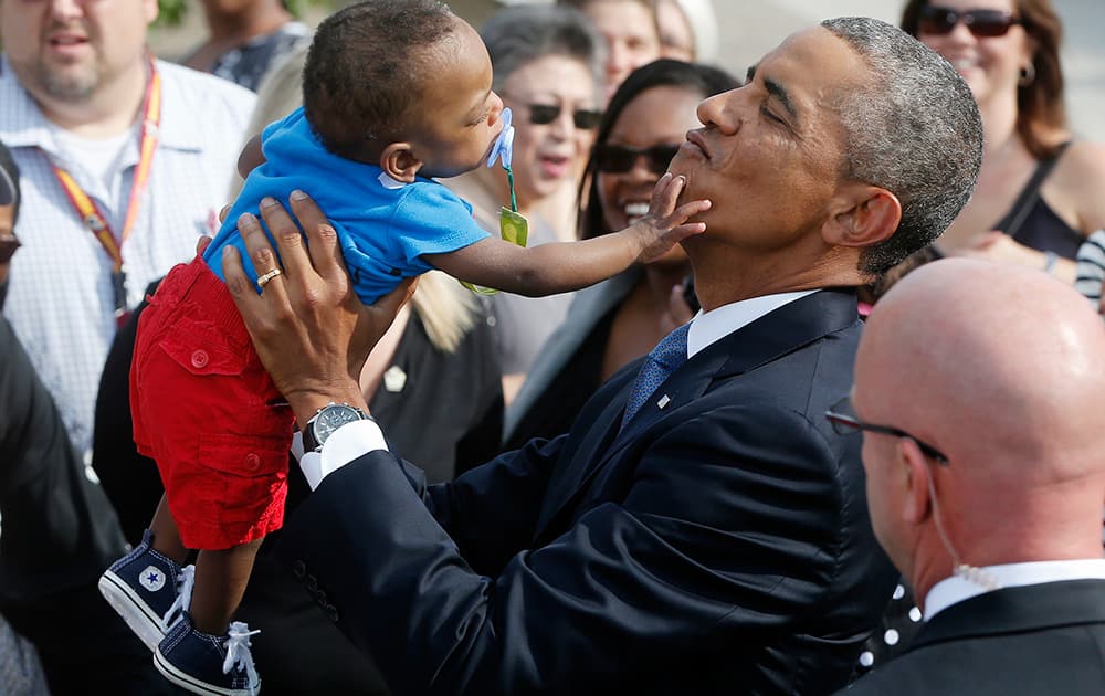 President Barack Obama picks up 13-month-old Larnell Maurice Perry Jr., grandson of Angelene C. Carter, who was killed in the September 11 attacks at the Pentagon, at the Pentagon.