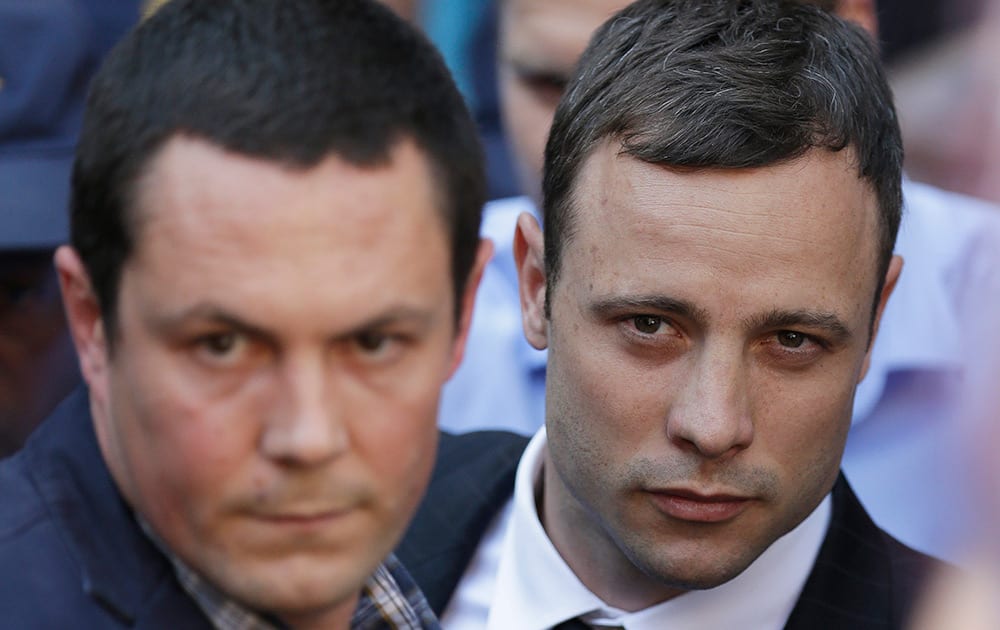 Oscar Pistorius, accompanied by a relative leaves the high court in Pretoria.