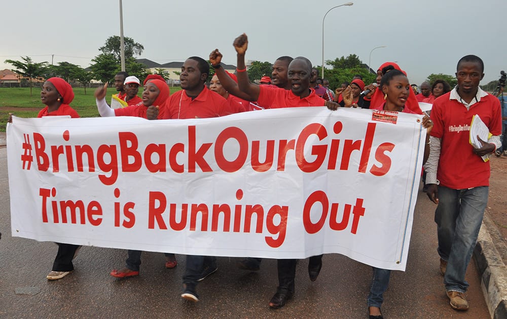 People shout slogans and hold a banner during a demonstration in Abuja, Nigeria.