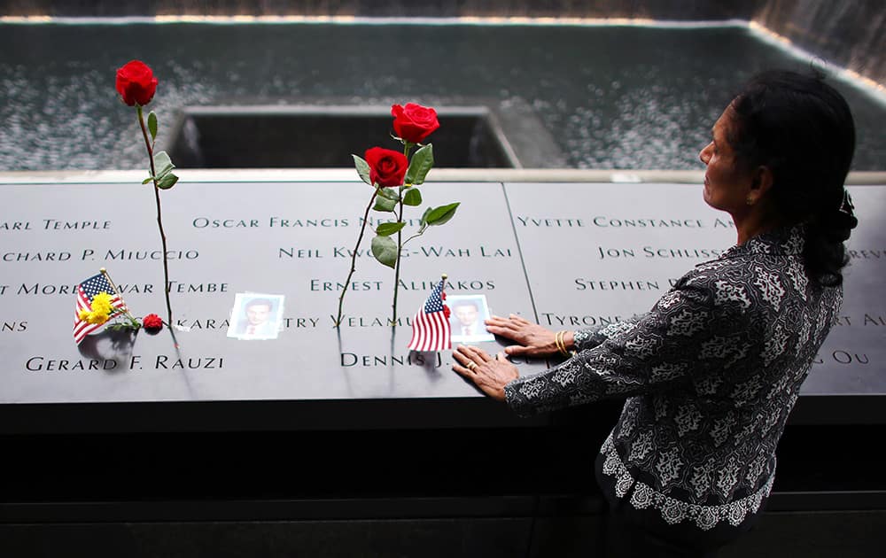 A woman grieves at her husband's memorial at South Tower Memorial Pool during memorial observances on the 13th anniversary of the Sept. 11 terror attacks on the World Trade Center in New York.