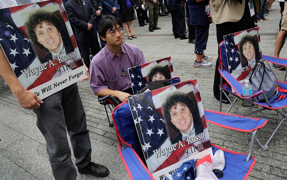 Lito Deleon holds a photo of friend Wayne Russo, who died in the Sept 11, 2001 attacks, during memorial observances held at the site of the World Trade Center in New York.