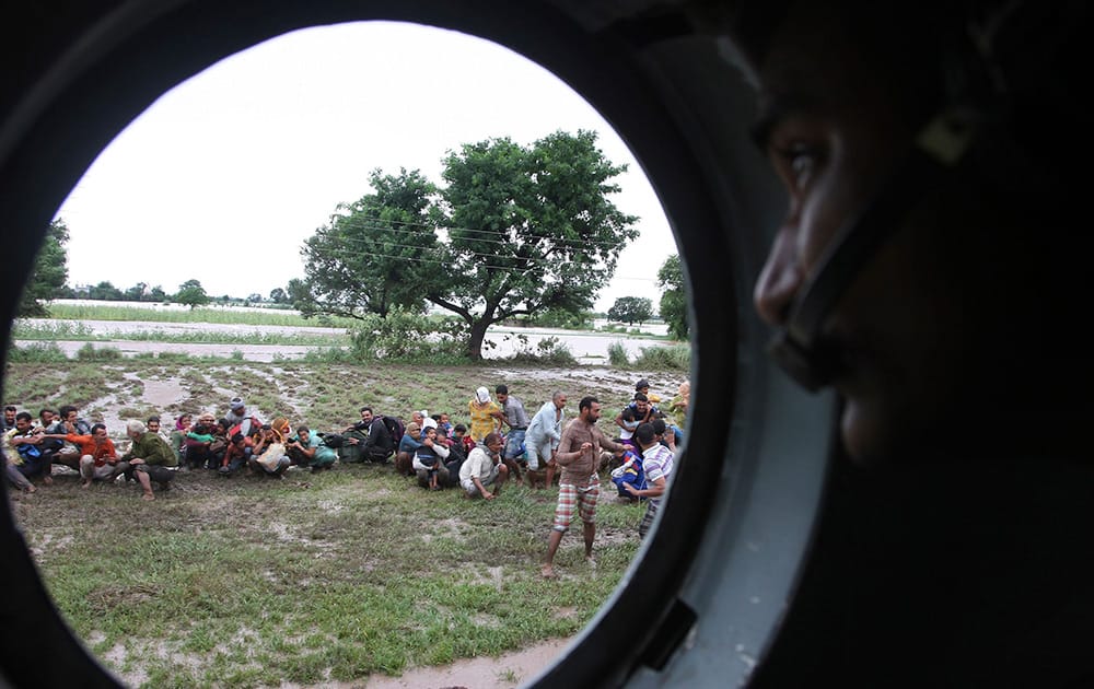 People marooned in flooding waiting to be rescued by an Indian Air Force helicopter, in Jammu and Kashmir.