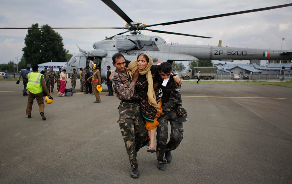 Indian soldiers carry a rescued flood victim at the Air Force Station in Srinagar.