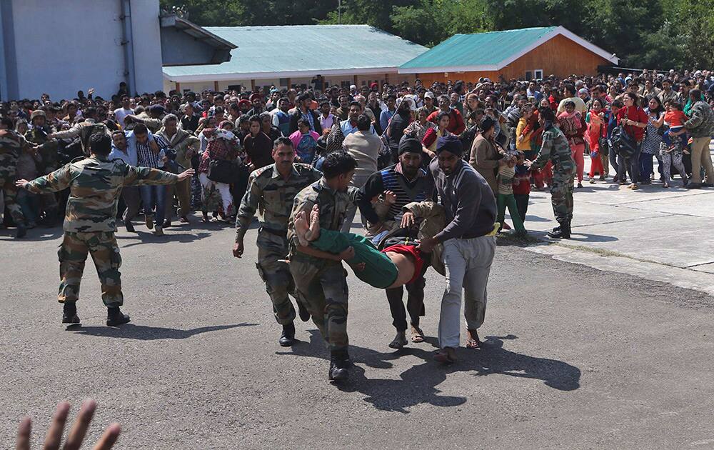 Indian army soldiers carry a seriously ill tourist towards a waiting Indian air force helicopter after he was rescued from a flooded neighborhood in Srinagar