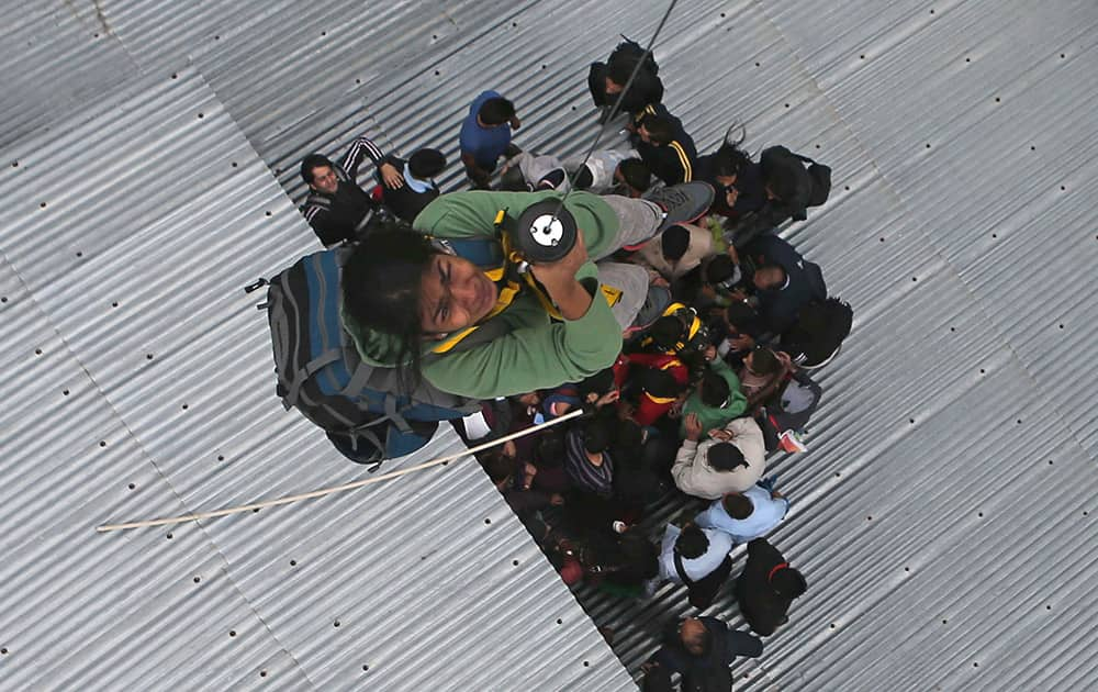 A tourist is airlifted from the roof of a of a five-story hotel, four of which are submerged in floodwaters, in Srinagar.