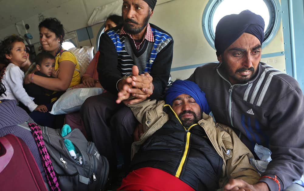 Tears roll down the cheeks of a relative of a seriously ill tourist as they hold him inside an Indian air force helicopter after being rescued from a flooded neighborhood in Srinagar.