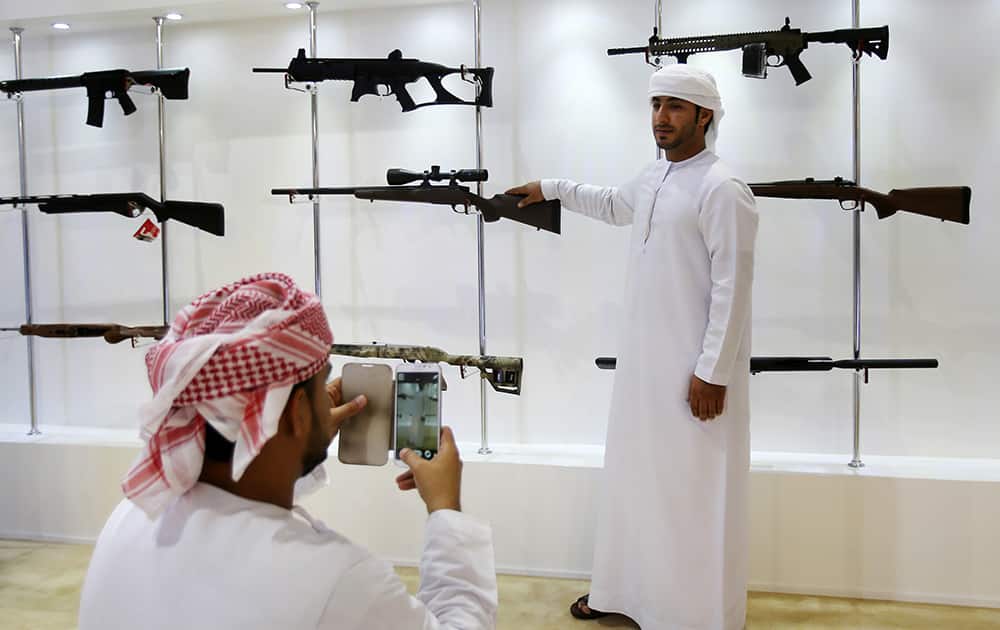 An Emirati takes a photo of his friend with his mobile phone at the International Hunting & Equestrian Exhibition in Abu Dhabi, United Arab Emirates. .
