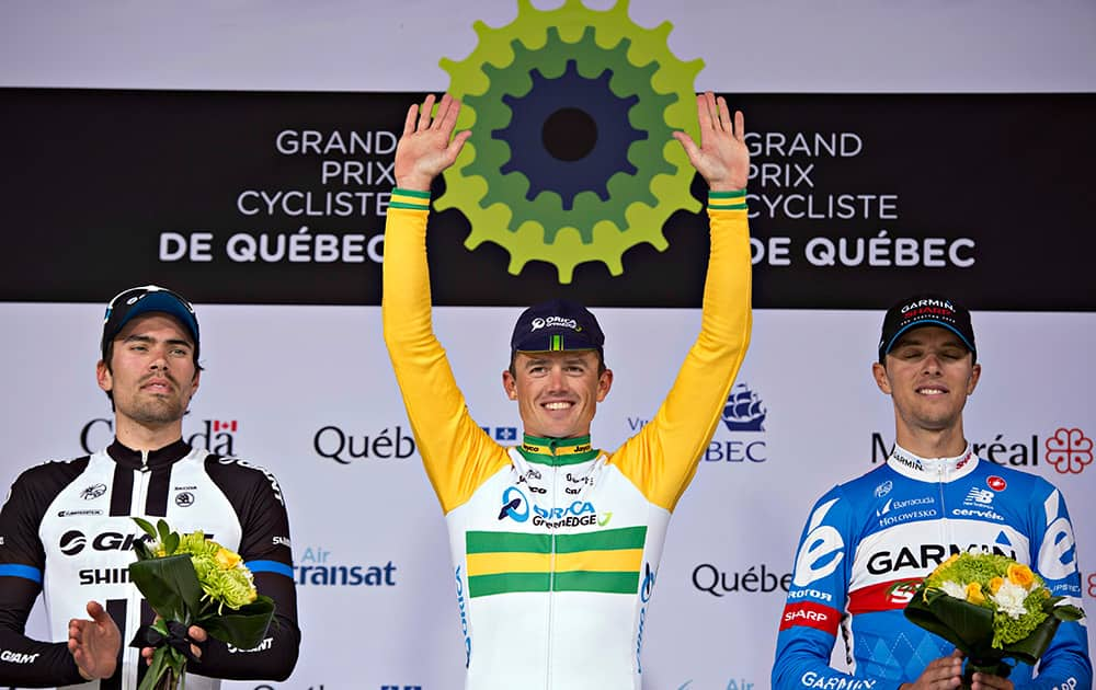 Simon Gerrans, center, of Australia, celebrates his victory on the podium with second place finisher, Tom Dumoulin, left, of the Netherlands and third place finisher Ramunas Navardauska, right, of Lituania Simon Gerrans, center, of Australia, celebrates his victory ahead of second place finisher Tom Dumoulin, left, of the Netherlands, at the Grand Prix Cycling of Quebec.