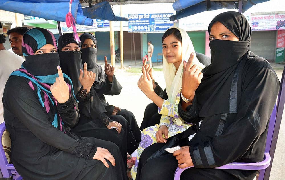 Women showing their inked fingers after voting in the assembly bypolls at Thakurdwara.