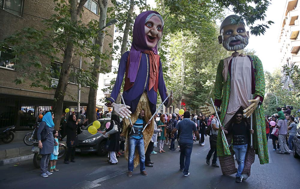 Iranian puppeteers display two huge puppets depicting an elderly Iranian couple wearing traditional dress during the first day of the 15th Tehran International Puppet Festival.