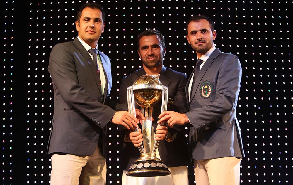 From left, captain of the Afghan national cricket team Mohammad Nabi and his teammates Karim Sadiq and Nawroz Mangal hold the ICC Cricket World Cup Trophy in Kabul international cricket stadium.