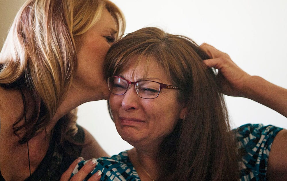 Susan Hunt, right, is consoled by her sister, Cindy Moss, as she speaks about her son, Darrien Hunt, who was killed by police Wednesday, at her home in Saratoga Springs, Utah. 