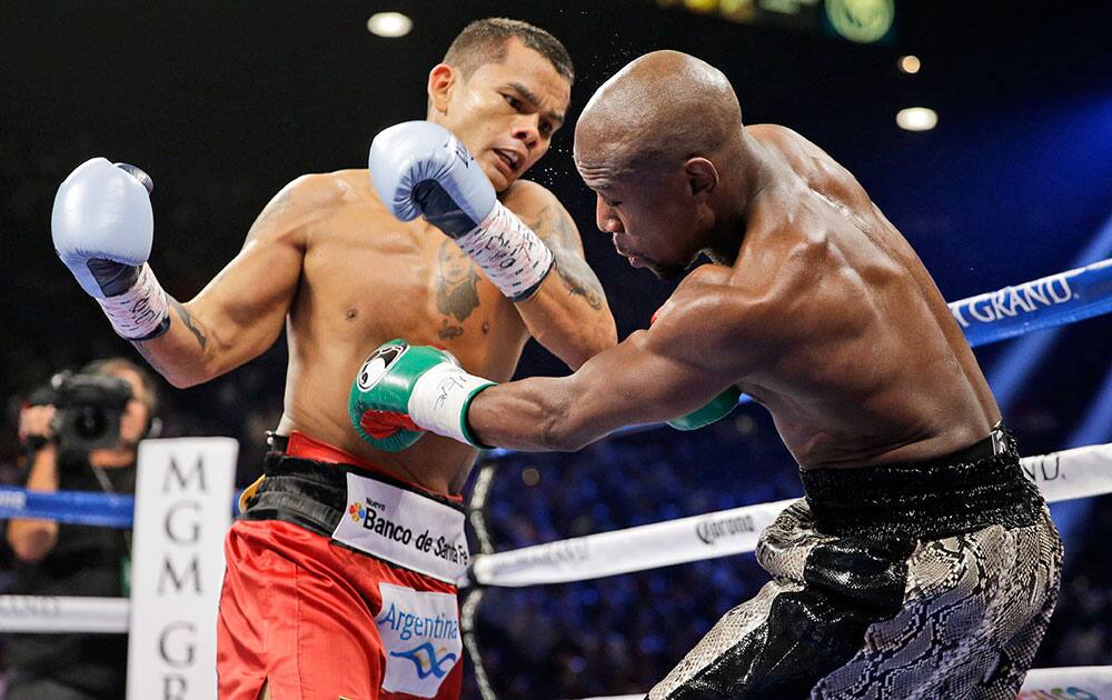 Marcos Maidana punches Floyd Mayweather, right, during their WBA welterweight and WBC super welterweight title fight, in Las Vegas.