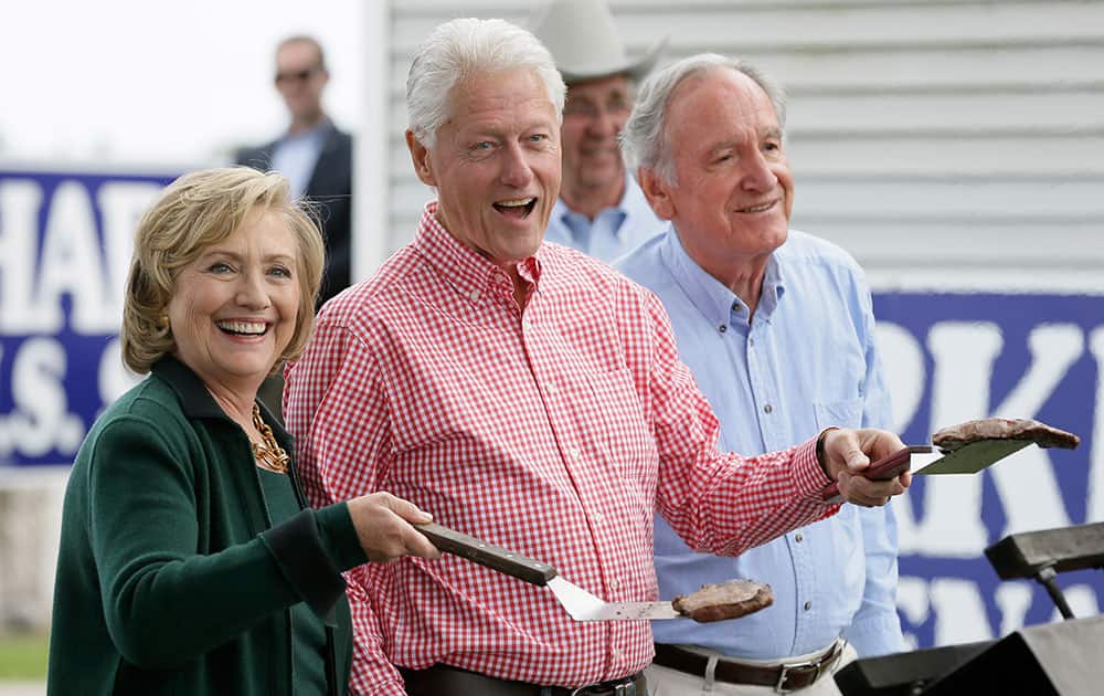 Former Sec. of State Hillary Rodham Clinton, former President Bill Clinton and U.S. Sen. Tom Harkin work the grill during Harkin's annual fundraising Steak Fry, in Indianola, Iowa. 