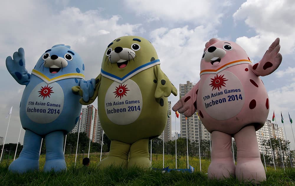 Three official mascots of the the 2014 Incheon Asian Games, from left, Barame, Vichuon and Chumuro pose for a photo at the 17th Asian Games Athletes' Village in Incheon, west of Seoul, South Korea.
