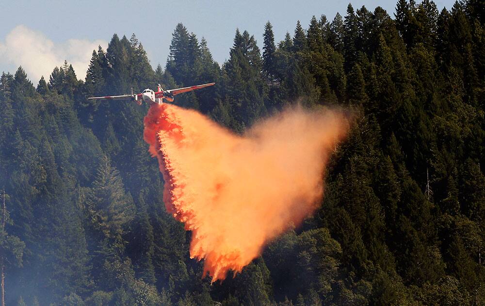 An aerial tanker drops its load of fire retardant on the fire near Pollack Pines, Calif.