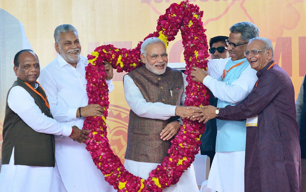 Prime Minister Narendra Modi is garlanded on his arrival at Sardar Patel International Airport in Ahmedabad.