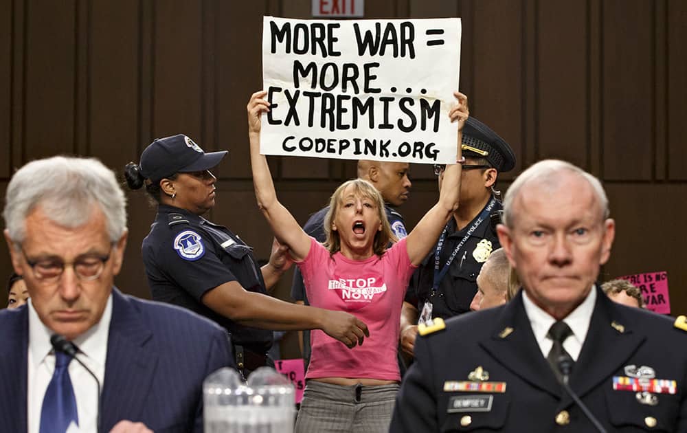 Members of the anti-war activist group CodePink interrupt a Senate Armed Services Committee hearing with Defense Secretary Chuck Hagel and Army Gen. Martin Dempsey, chairman of the Joint Chiefs of Staff, on Capitol Hill in Washington.