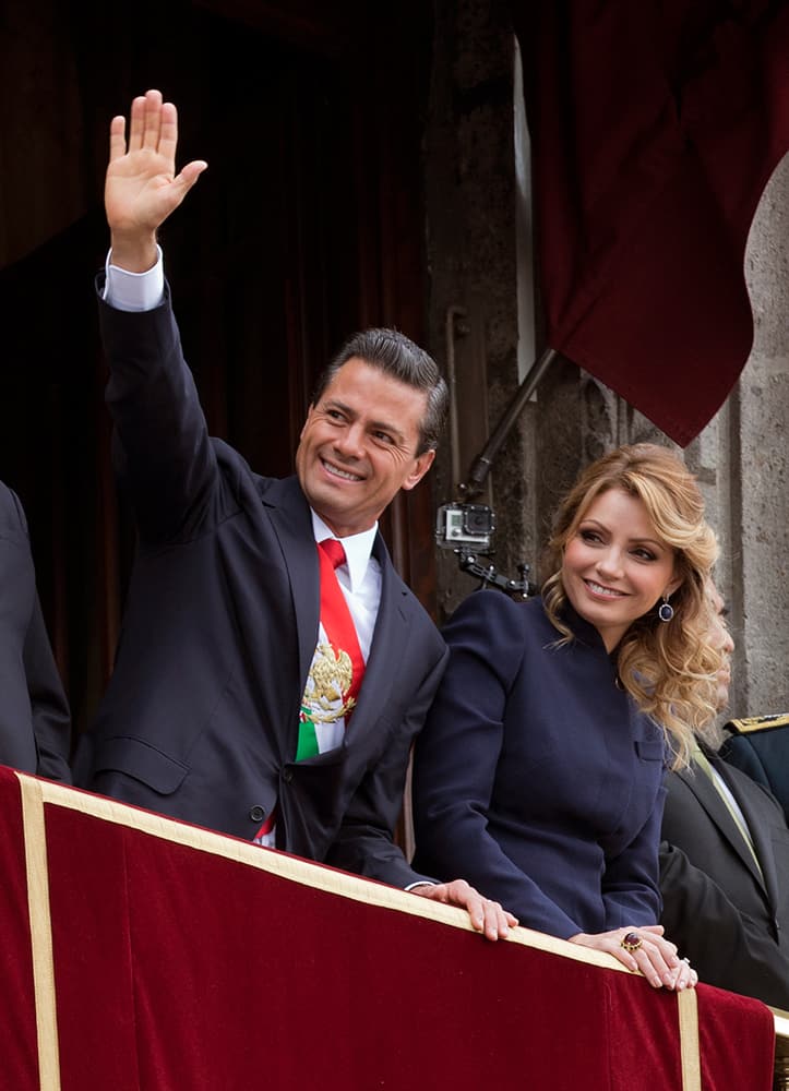 Mexico's President Enrique Pena Nieto waves as he stands with his wife Angelica Rivera while overseeing Independence Day celebrations from the balcony of the National Palace, in central Mexico City.