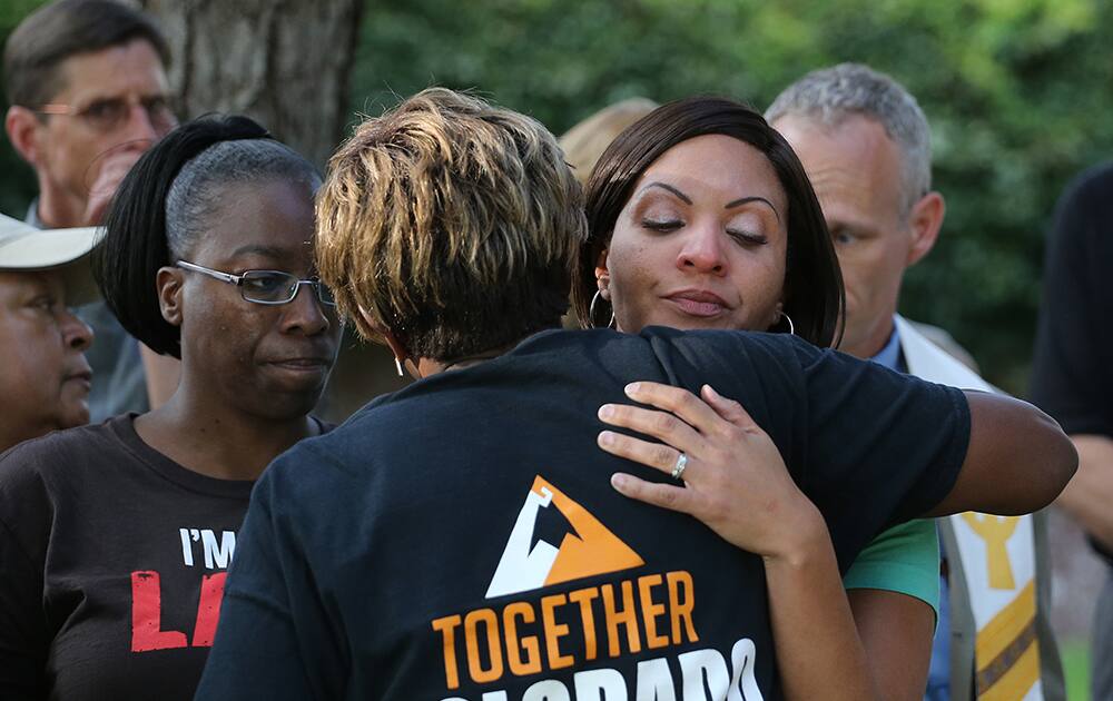 Jasmine Lima-Marin gets a hug during a gathering of faith leaders and supporters for a vigil in front of the Governor's Mansion in Denver.