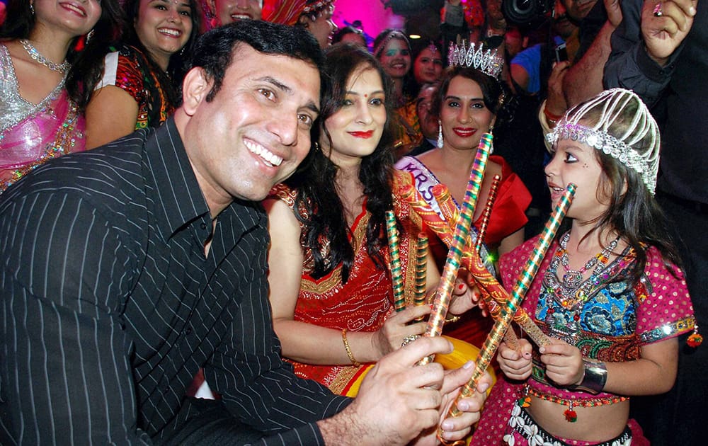 Former cricketer VVS Laxman plays Dandiya with a little girl during the unveiling of Dildar Dandiya Bash in Hyderabad.