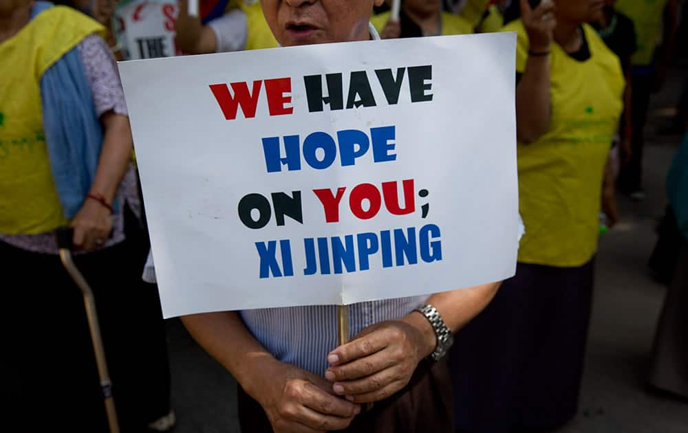 An Exile Tibetan man holds a banner during a protest to highlight Chinese control over Tibet, coinciding with the visit of Chinese President Xi Jinping in New Delhi.