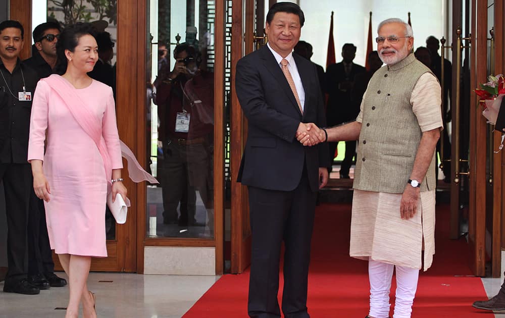 Prime Minister Narendra Modi poses with Chinese President Xi Jinping as he welcomes him upon his arrival at a hotel in Ahmadabad.