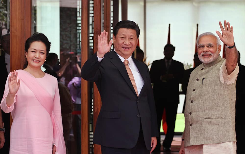 Prime Minister Narendra Modi, Chinese President Xi Jinping and Xi’s wife Peng Liyuan, wave to the media after Modi received them upon arrival at a hotel in Ahmadabad.