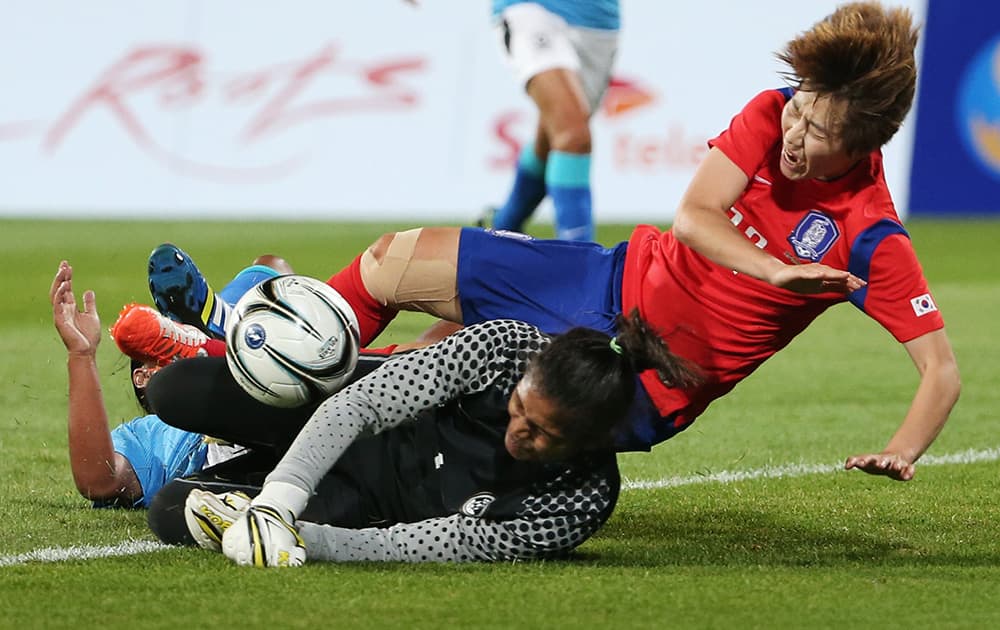 South Korea's Younga Yoo, right, is tackled by India's goalkeeper Aditi Chauhan, foreground, during their women's first round group A soccer match at the 17th Asian Games in Incheon, South Korea.