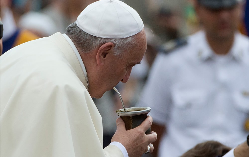 Pope Francis drinks from a mate gourd, a traditional South American cup, he was offered as he arrived for his weekly general audience, in St. Peter's Square, at the Vatican.