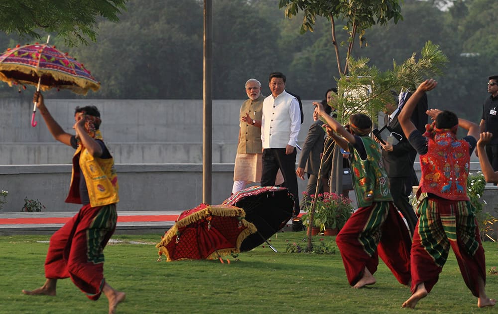 Chinese President Xi Jinping and Indian Prime Minister Narendra Modi watch a cultural performance as they walk on the Sabarmati River front in Ahmadabad.