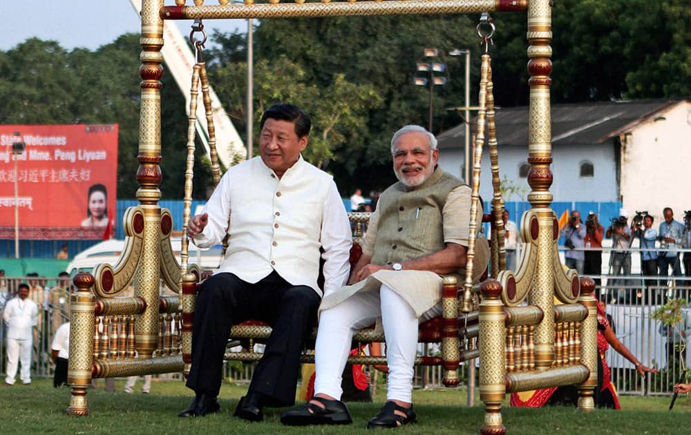 Chinese President Xi Jinping, left and Indian Prime Minister Narendra Modi, sit on a traditional swing at the Sabarmati River front in Ahmedabad.