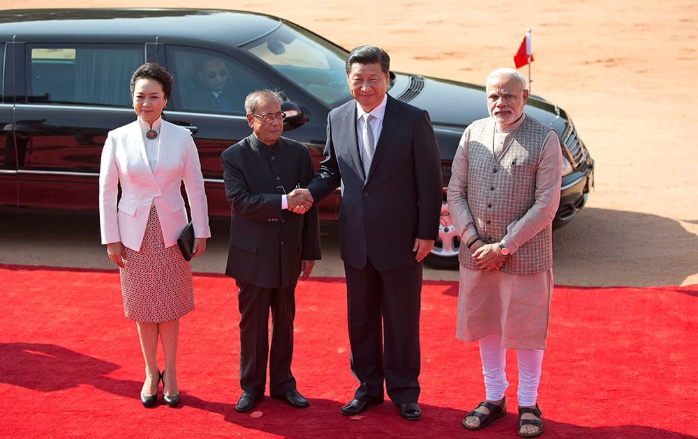 Indian President Pranab Mukherjee, second left, shakes hand with visiting Chinese President Xi Jinping, as Indian Prime Minister Narendra Modi and Xi's wife Peng Liyuan stand beside them in New Delhi.